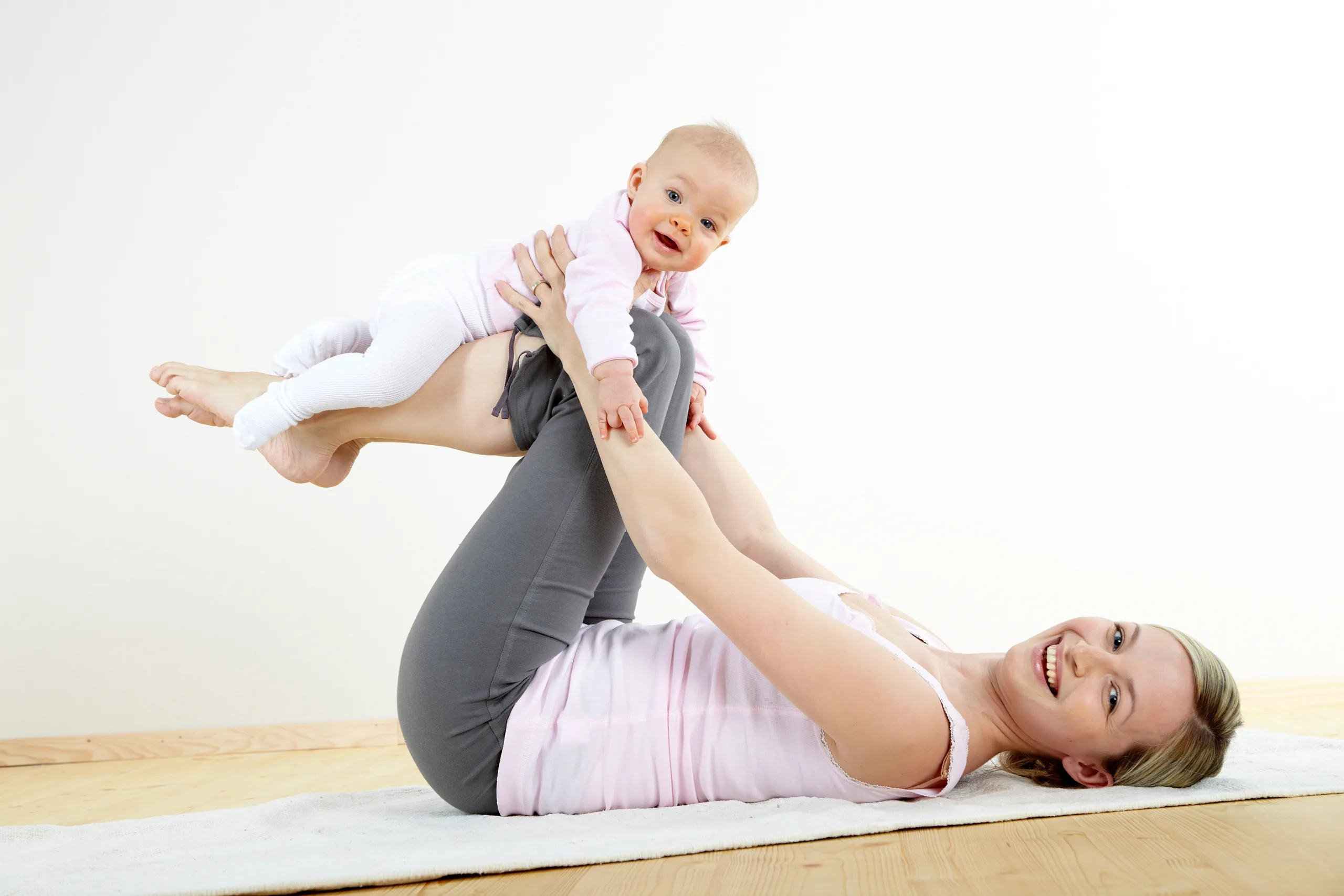 Mother and daughter enjoying a Stay and Play gymnastics session with mats and soft play equipment.
